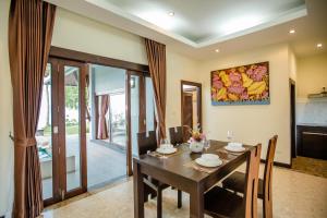 a dining room with a wooden table and chairs at 2H RESORT KOH SAMUI in Koh Samui