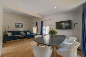 a living room with a table and white chairs at Villa Poncelet in Paris