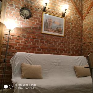 a bedroom with a brick wall with a bed and a clock at Apartament Królewski z baldachimem Centrum in Olsztyn