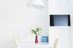 a white table with a vase of flowers on it at Hotel Blaue Blume in Freiberg