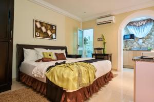 1 dormitorio con 1 cama grande y paredes amarillas en The Ritzz Exclusive Guest House en Accra