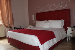 a bedroom with a large bed with a red headboard at B&B Milu' in Crotone