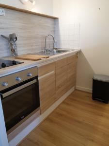 a kitchen with a sink and a stove at Cosy Er Lann Gîte Cèdre in Val Couesnon