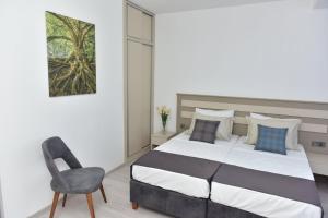 a bedroom with a bed and a chair at Alya Rooms in North Nicosia