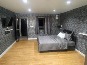 芭達雅中心的住宿－GW guesthouse，一间卧室配有一张床和一台电视