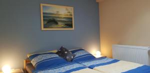 ein Schlafzimmer mit einem Bett mit einem Bild an der Wand in der Unterkunft Feriendomizil im Lieper Winkel in Liepe