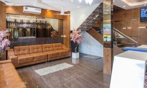 a lobby with a brown couch and a bar at Hotel Hometown Near US Embassy BKC in Mumbai