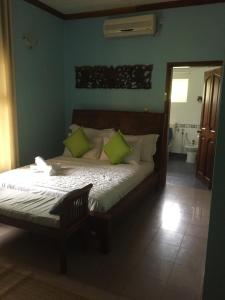 a bedroom with a large bed with green pillows at Bay View Villa Seychelles in Anse Boileau
