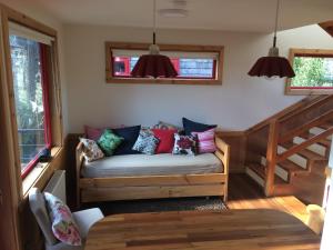 a living room with a couch with colorful pillows at Almabosque Cabañas in Puerto Varas