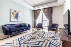 a living room with a blue couch and chairs at Frank Porter - Mon Reve in Dubai