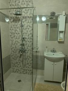 La salle de bains est pourvue d'une douche et d'un lavabo. dans l'établissement ComfortApartment IGLIKA 2, à Borovets