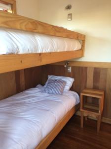 two bunk beds in a room with a side table at Almabosque Cabañas in Puerto Varas