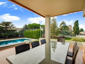 eine Terrasse mit einem Tisch und Stühlen sowie einem Pool in der Unterkunft Belvilla by OYO Bon Relax Espai in Sant Pere Pescador