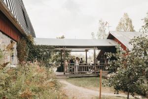 a group of people standing in a pavilion in a barn at Varjola Holiday Center in Laukaa