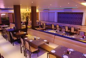 a restaurant with tables and chairs and a bar at Hotel Rajtara in Satara