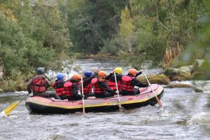a group of people in a raft on a river at Varjola Holiday Center in Laukaa