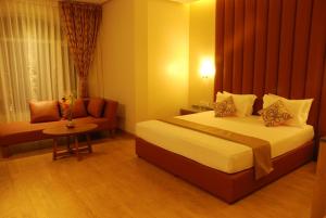 ein Hotelzimmer mit einem Bett und einem Stuhl in der Unterkunft Hotel Rajtara in Satara