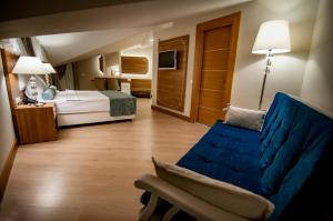 a hotel room with a blue couch and a bed at Exelans Hotel in Fethiye