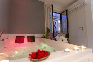 a bathroom with a tub with red flowers in it at Duomo Luxury Suite Catania in Catania