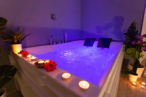 a bath tub with candles in a purple room at Duomo Luxury Suite Catania in Catania