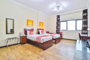 1 dormitorio con 2 camas y escritorio. en Grand PJ Hotel - Free Parking en Ras al-Jaima