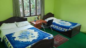 A bed or beds in a room at New Pokhara Lodge - Pokhara Lakeside