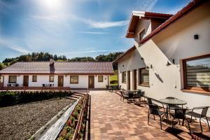 a patio with tables and chairs and a building at Ma-Mela in Polańczyk