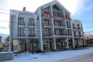 a large white building with snow in front of it at Three Penguins in Bakuriani