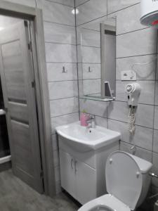 a bathroom with a toilet and a sink and a mirror at Studio on Stefan 37 in Bălţi