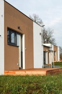 ein Haus mit einer Veranda neben einem Gebäude in der Unterkunft Apartmány NMNM REZIDENCE NAD MĚSTEM in Nové Město na Moravě