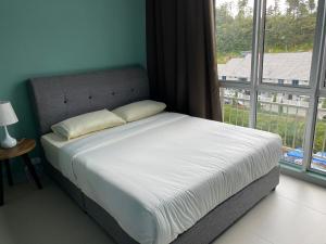 een bed in een kamer met een groot raam bij Cameron Highlands Apartment HL in Tanah Rata
