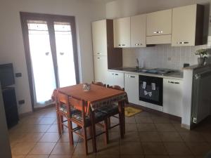 a kitchen with a wooden table and a table and chairs at PRINCESS HOUSE in Ladispoli