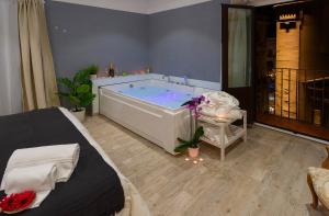 a bath tub in a room with a bed at Duomo Luxury Suite Catania in Catania