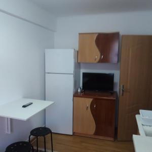 a kitchen with a white refrigerator and a table and chairs at RIO STUDIO in Sinaia