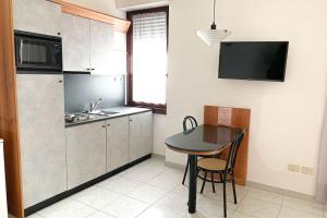 a kitchen with a table and a small kitchen with a sink at Majestic Suite in San Benedetto del Tronto