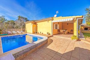 a backyard with a swimming pool and a house at Can Parets in Santanyi