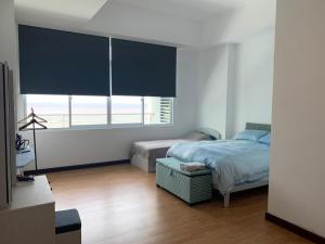 um quarto com uma cama e uma grande janela em Bay Resort Condominium, 7, Beach-front Sea view, 6-8 PAX em Miri