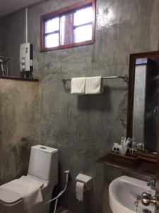 a bathroom with a toilet and a sink and a window at Tara Beach Resort Udonthani in Udon Thani