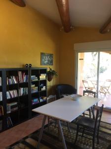 comedor con mesa, sillas y estante para libros en Le Voltigeur du Ventoux, en Entrechaux