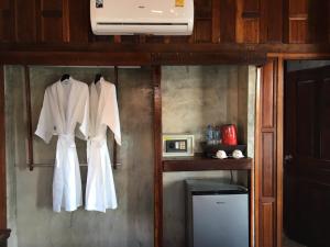 a couple of white dresses hanging on a wall at Tara Beach Resort Udonthani in Udon Thani