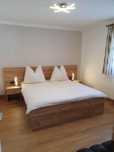 una camera da letto con un letto con lenzuola e luci bianche di Rohrmoser Appartements a Sankt Johann im Pongau