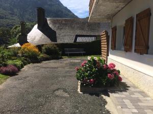 uma casa com um banco e flores em frente em Appartement été et hiver 1 à 5 pers. Cauterets em Cauterets