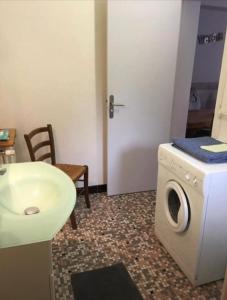 a bathroom with a washing machine and a sink at Appartement été et hiver 1 à 5 pers. Cauterets in Cauterets