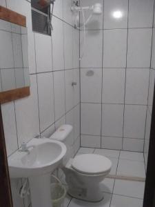 a white bathroom with a toilet and a sink at O Refugio in Mata de Sao Joao