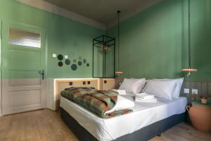 a bedroom with a bed with a green wall at Beautiful best location apartment Green Mouse in Plovdiv