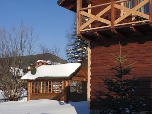 a log cabin with snow on the roof at Dobryi Hutsul 2 in Mykulychyn