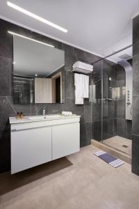 a bathroom with a white sink and a shower at Sempre Viva Suites in Monemvasia