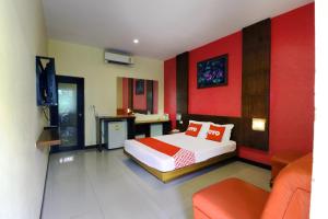 a bedroom with a bed and a red wall at OYO 547 Happy Home in Bangkok