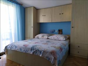 Schlafzimmer mit einem Bett mit blauen Wänden und einem Fenster in der Unterkunft Apartman Anđela in Podgora