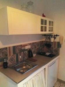 uma cozinha com um lavatório e uma bancada em appartamentino in villa settecentesca em Bagheria